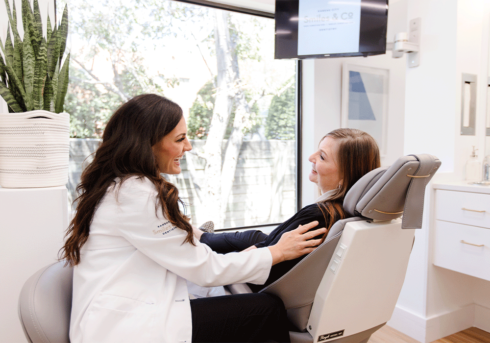 Dr. Nikki talking chair-side with a patient.