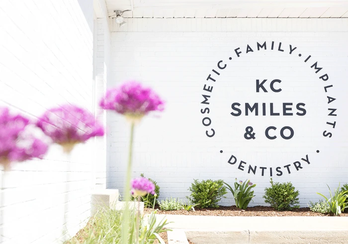 Building exterior with KC Smiles & Co Cosmetic, Family, and Implants Dentistry mural.